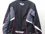 the jacket is hanging on a hanger on the wall