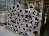 Plusieurs rouleaux de papier toilette sont empilés sur une palette dans un entrepôt