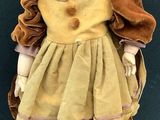 a small doll that is wearing a hat and dress