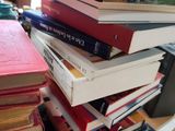 many books stacked on top of each other on a desk