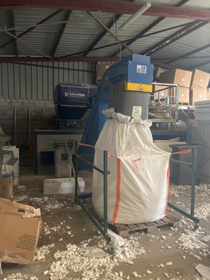 une photo d'une usine avec un grand sac rempli d'une substance blanche