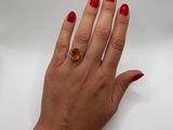 woman ' s hand with red manicured nails and a gold ring