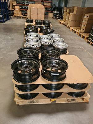 un tas de roues est posé sur une palette dans un entrepôt