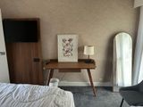 a bedroom with a bed and a desk with a mirror