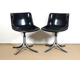 une paire de fauteuils pivotants noirs avec des pieds chromés et une assise en cuir noir