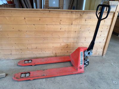 une palette rouge posée devant un mur en bois