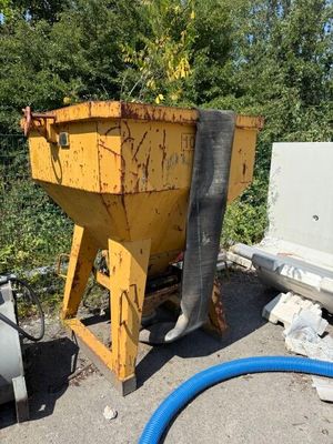 a yellow dumpster sitting next to a blue hose