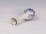an old blue and white vase with a gold rim sitting on a white surface