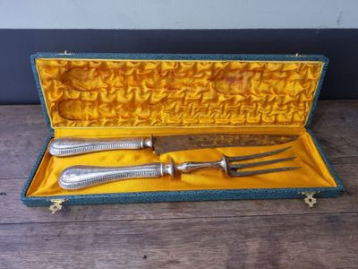 two forks and a knife in a case on a table