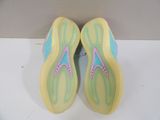 yellow and blue sneakers with pink trims are on a white surface