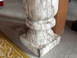 a marble vase sitting on the floor next to a rug