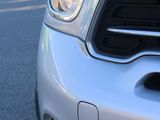 a close up of a silver mini cooper on the street