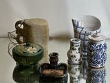 many different vases and jars on a glass table