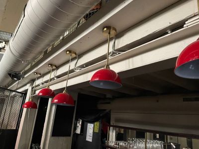 several red lamps hanging from the ceiling of a restaurant