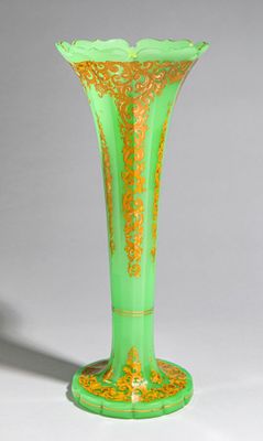 vase vert et doré sur fond blanc, avec une ombre au sol
