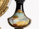 a vase with a painting on it next to a clock