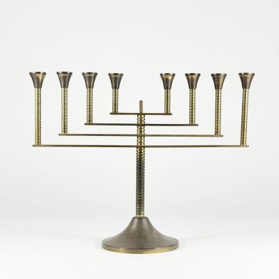 a brass menorat with five candles on a stand