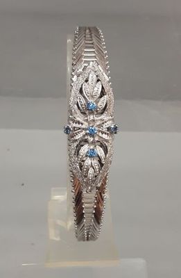 un gros plan d'une bague en argent sertie de pierres bleues et blanches