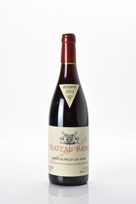 une bouteille de vin rouge posée sur une surface blanche, avec un fond blanc