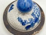 a small blue and white bowl with a blue ball on top