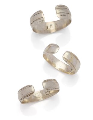 trois bracelets rigides en argent sur fond blanc
