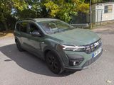 a green car that is parked on the side of the road
