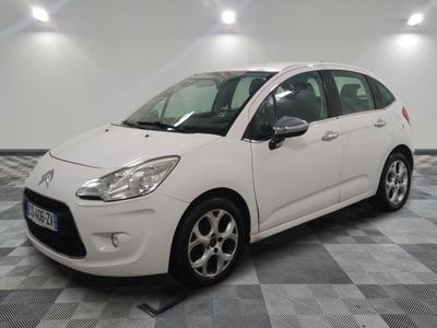 the small white car is parked on a checkered floor