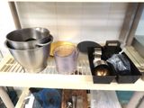a metal shelf with a metal bowl and other kitchen items