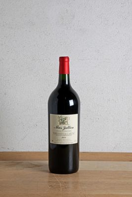 a bottle of red wine sitting on a wooden table