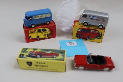 Plusieurs petites voitures sont posées sur des cartons, sur une table.