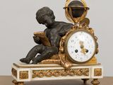 une statue représentant un garçon en train de lire un livre sur une horloge
