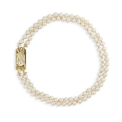 un bracelet de perles blanches avec un fermoir doré sur fond blanc