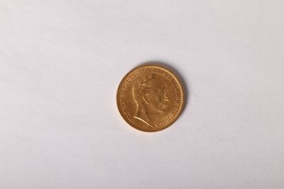 gros plan d'une pièce d'or sur une surface blanche