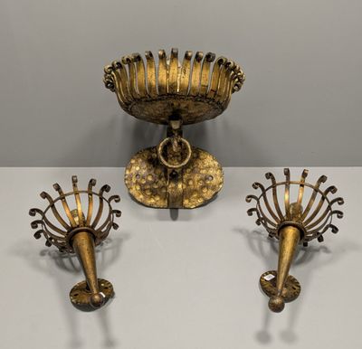 trois bougeoirs en laiton et un bol posés sur une table blanche