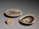 trois pièces de poterie ornées de motifs, posées sur une table