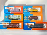 six boîtes contenant des trains miniatures posées sur une surface blanche