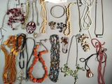 a lot of necklaces and bracelets that are on a table