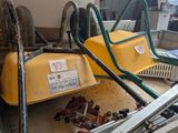 une machine jaune qui trône au milieu d'un tas de ferraille