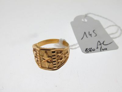 une image d'une bague en or sur une surface blanche avec une étiquette de prix