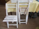 une table avec des chaises et une nappe sur laquelle est posée une pancarte