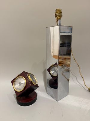 un miroir sur lequel est fixée une horloge et une lampe posée sur une table