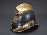 an old helmet with a gold crown on it on a black background
