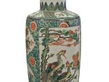 a vase with a bird on it sitting on a table