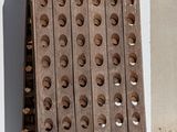 a wooden board with holes on it next to a wall