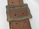 an old leather belt with a metal buckle on a white surface