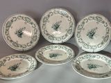 six green and white plates with floral designs on them