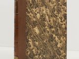 a book with a brown cover sitting on top of a white table
