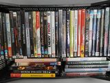 une étagère noire sur laquelle sont posés plusieurs DVD