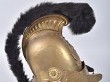 a gold helmet with black fur on top of a wooden stand
