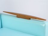 a surfboard on the back of a blue couch
